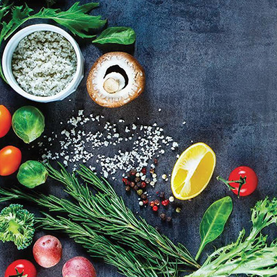 A colorful assortment of fresh vegetables and herbs neatly arranged on a wooden table.
