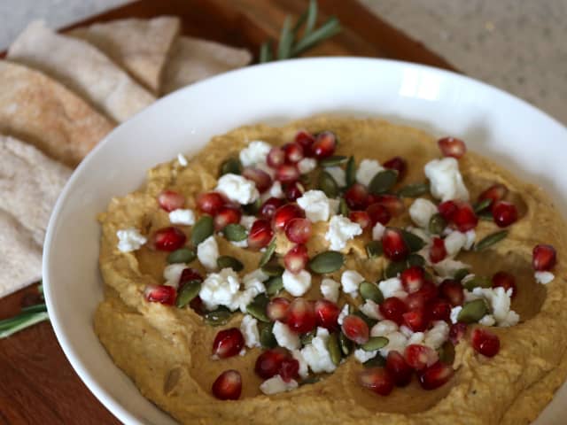 Photo of a white bowl filled with butternut squash hummus