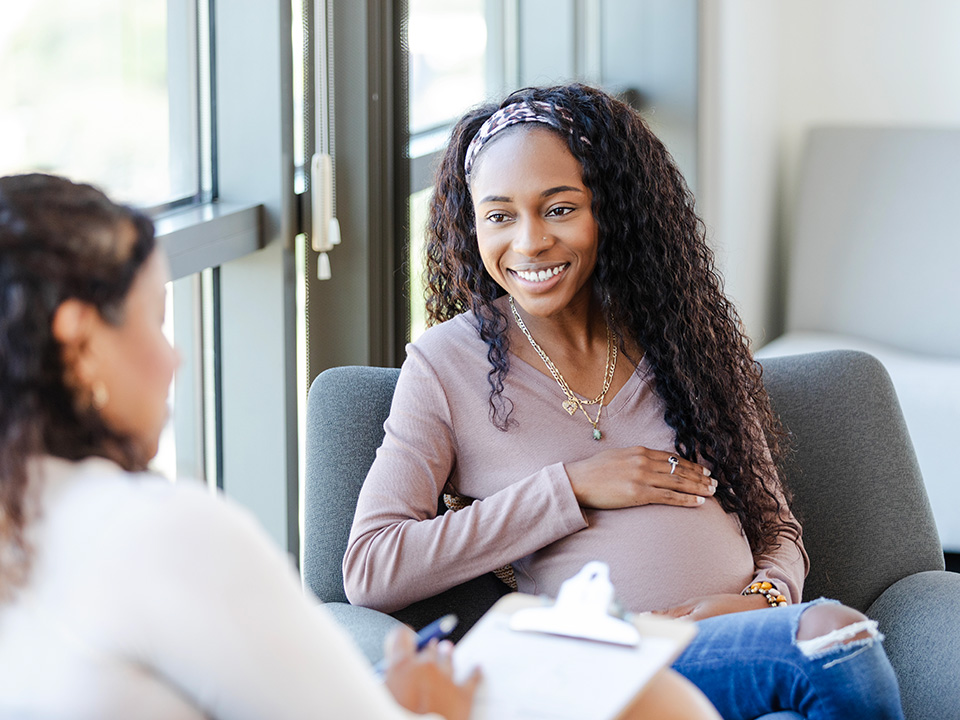 Pregnant patient having a conversation with her care provider during an appointment