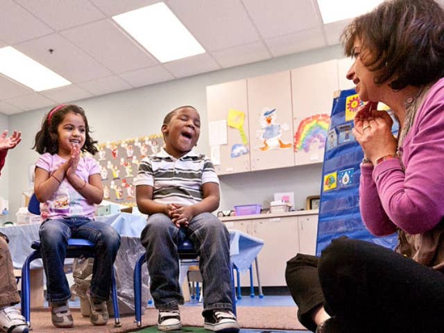 Female working with group of young children.