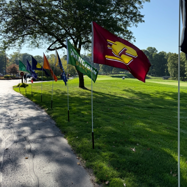 Michigan college flags in the green grass at a golf course 