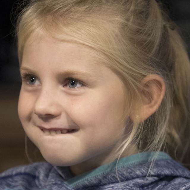 Young girl with blonde hair smiles