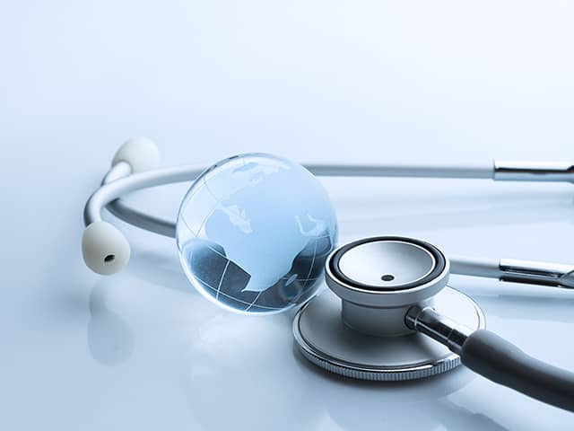 Close-up of a stethoscope with a transparent globe, symbolizing global healthcare and international medical practice.