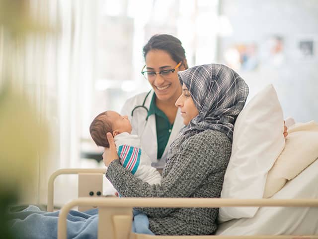 A doctor listens to an older man's chest with a stethoscope during a medical examination.