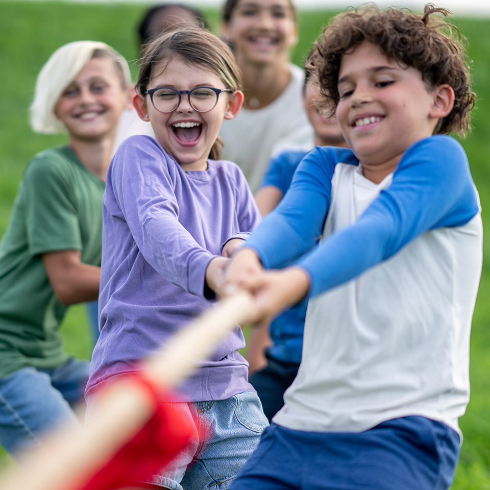 A group of young children playing tug of war.