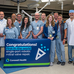 group of doctors and nurses with congratulations sign for robotic surgery success