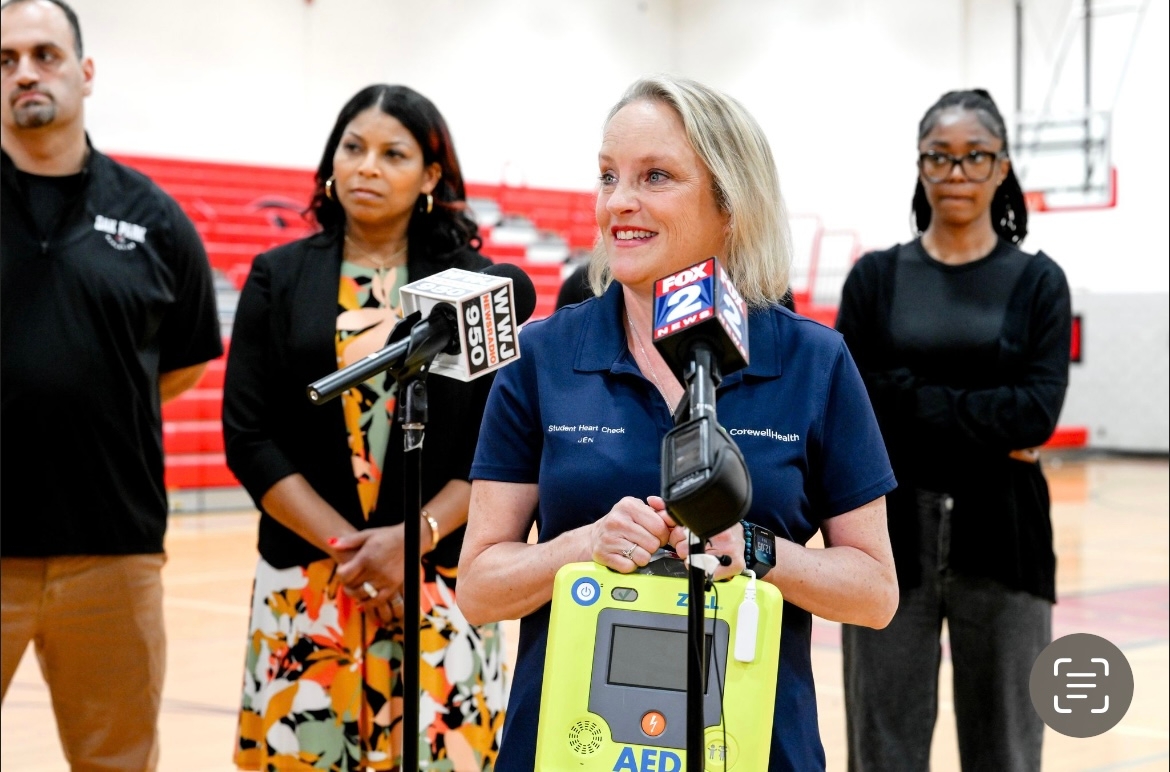 Woman in navy blue Corewell Health shirt speaks in front of group
