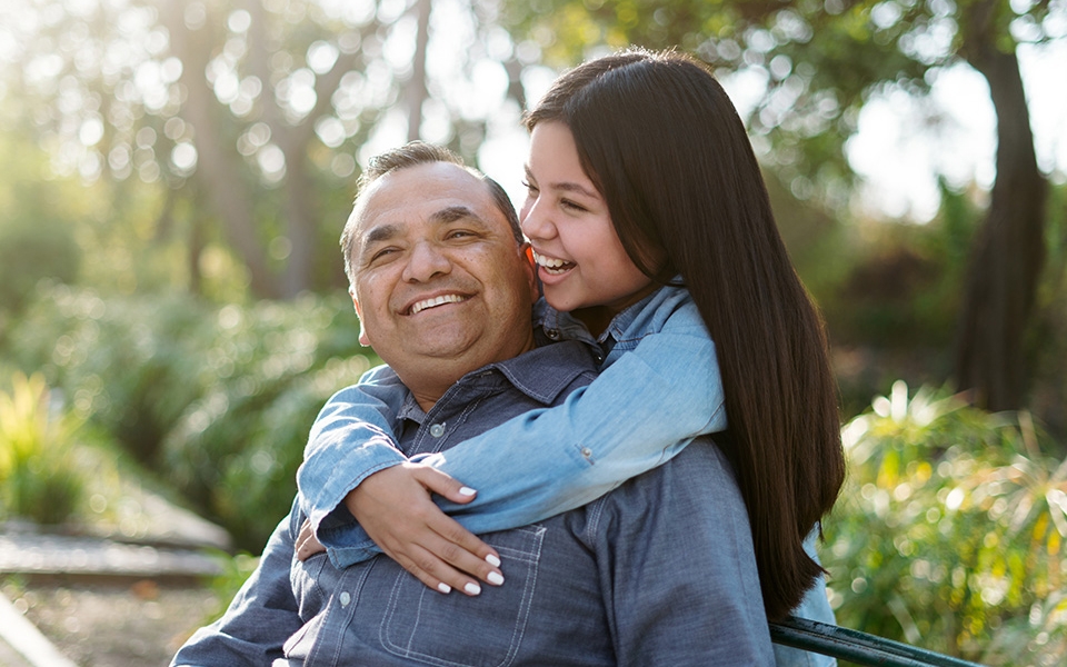 Happy young child hugs her smiling father