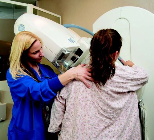 xray tech performing a mammography scan on patient