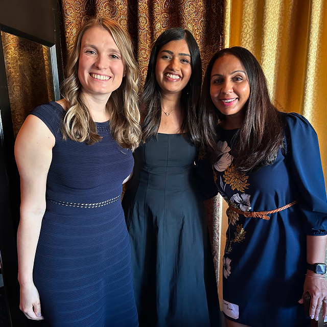 Three attendees posing together for a photo during a residency celebration dinner