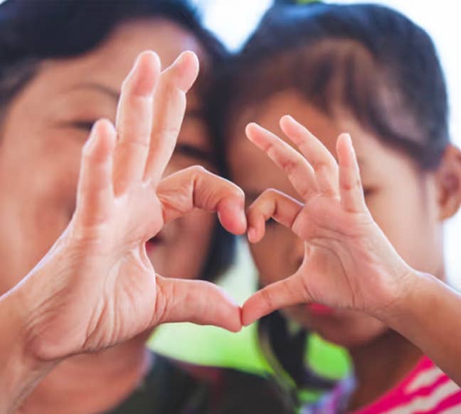 Woman and child making a heart shape with their hands
