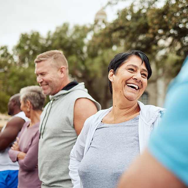 A diverse group of people smiling and laughing together, showcasing joy and camaraderie in a community.
