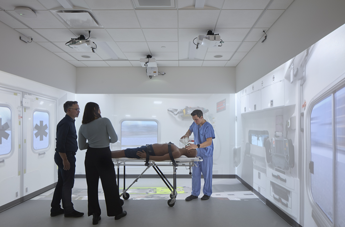 A group of healthcare professionals and family members gathered around a patient in a hospital room.