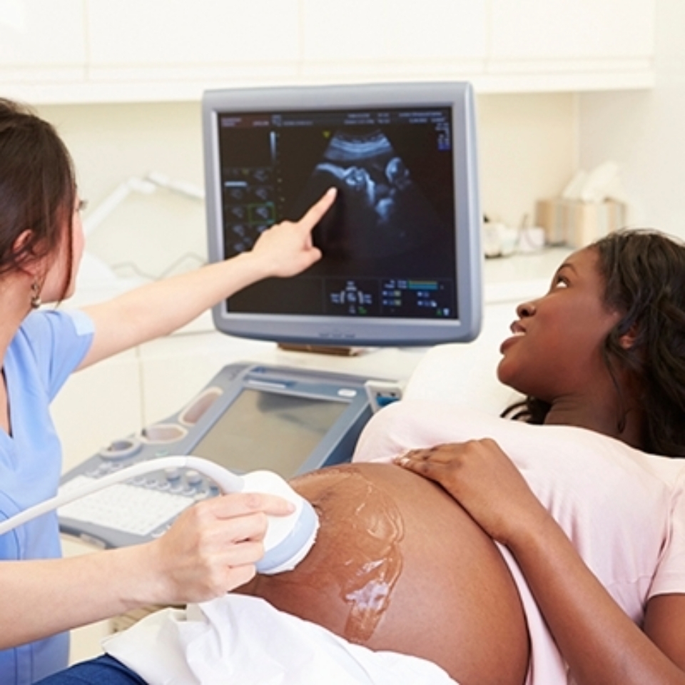 Pregnant young Black woman gets an ultrasound from a Corewell Health imaging specialist