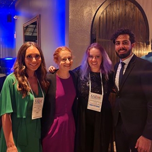 Four individuals gathered at an event, representing a diverse group engaged in conversation and networking.