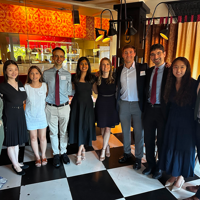 Group of residents posing together for a photo during a residency celebration dinner