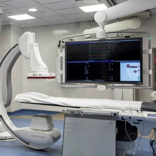 Operating room with table, a large screen and other equipment used during a surgery