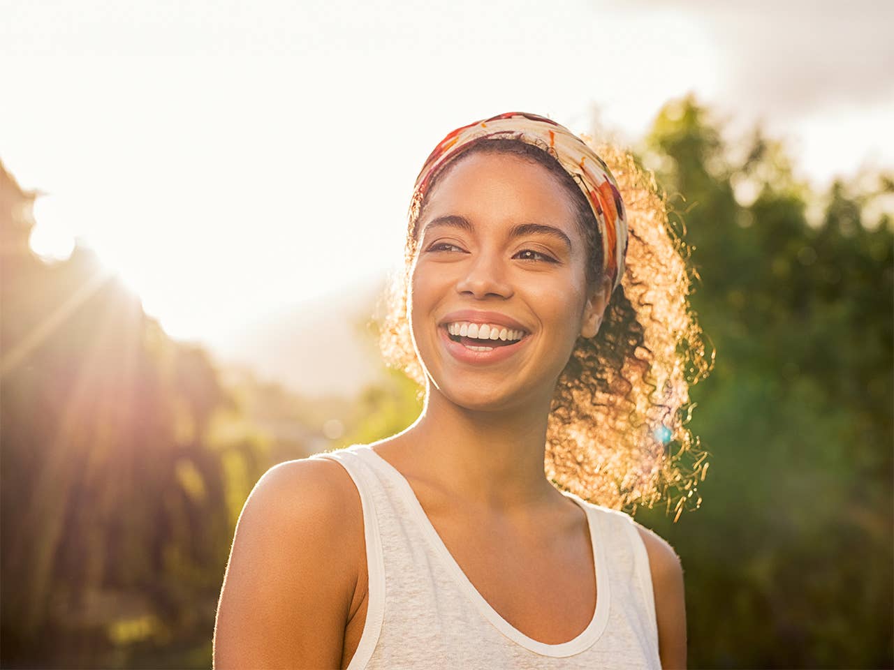 Smiling Black woman standing outside in the sunset