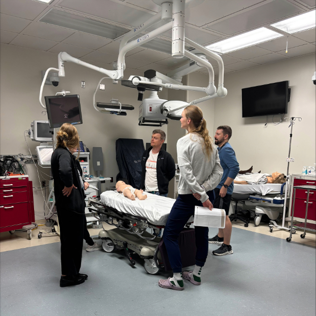 Fellows and staf having a conversation around an operating table in an operating room