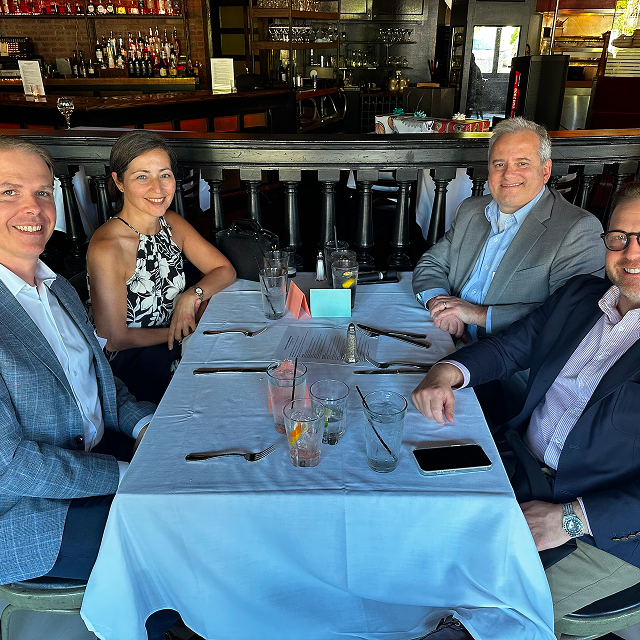 Four attendees seated together at a restaurant table during a residency celebration dinner