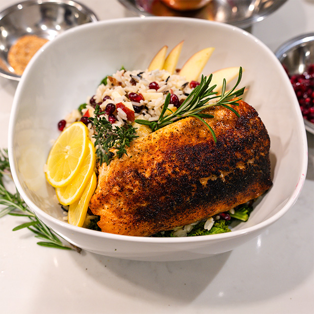 A bowl of food garnished with a fresh lemon wedge, showcasing a vibrant and appetizing presentation.