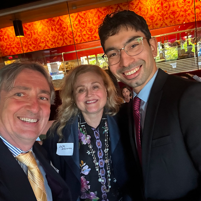 Three attendees posing together for a selfie during a residency recognition event