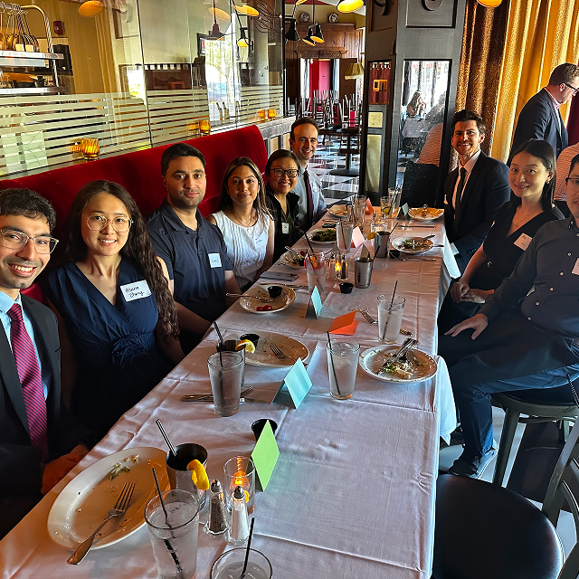 Residents and faculty seated together at a banquet table during a residency celebration dinner