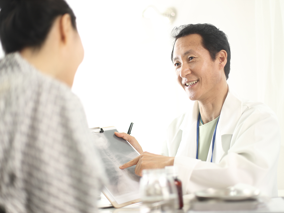 A doctor is engaged in conversation with a patient in a clinical setting.