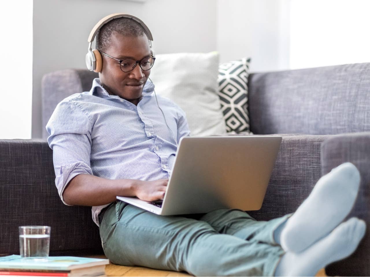 Man sitting on couch working on his laptop