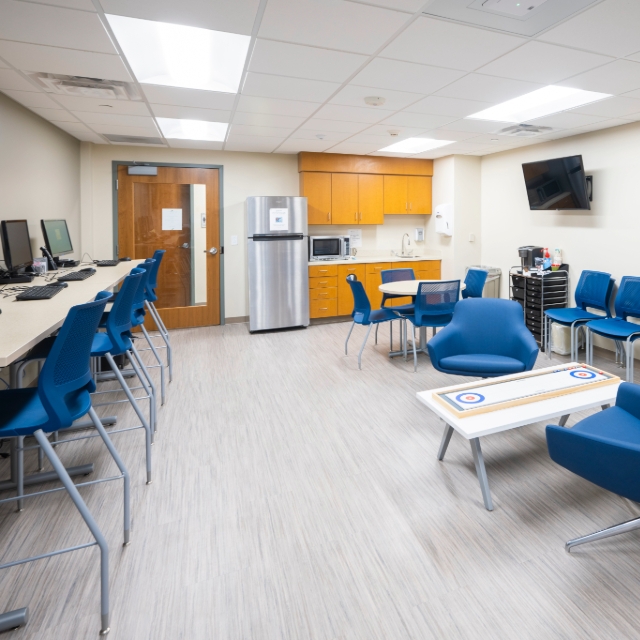 Resident lounge at Niles with a kitchen, chairs, and computers