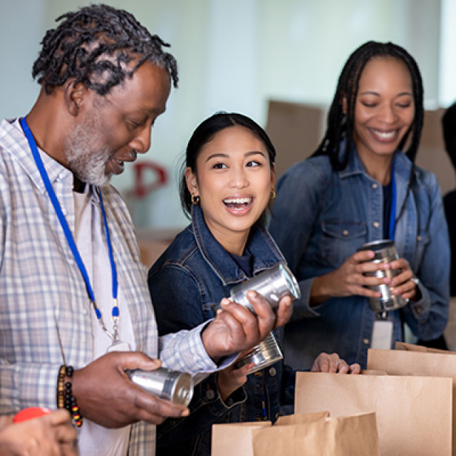 community members helping pack paper bags of food