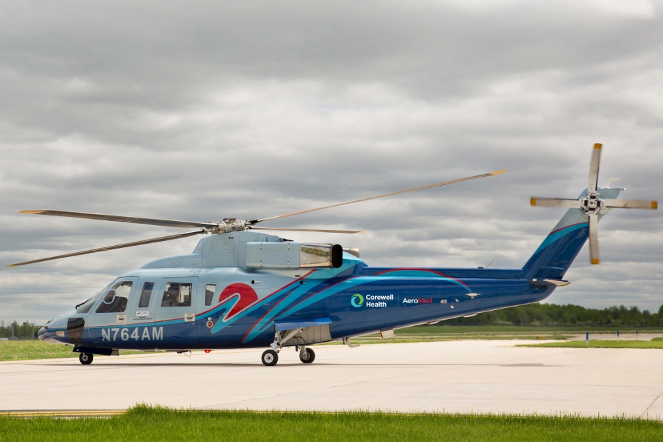 Corewell Health Aero Med transport helicopter on airport runway