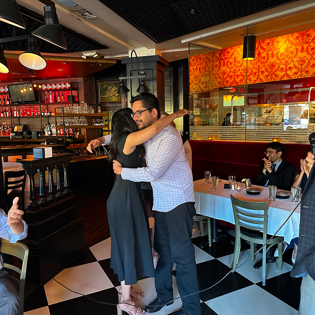 Award recipient embracing a presenter during a recognition ceremony at a restaurant event