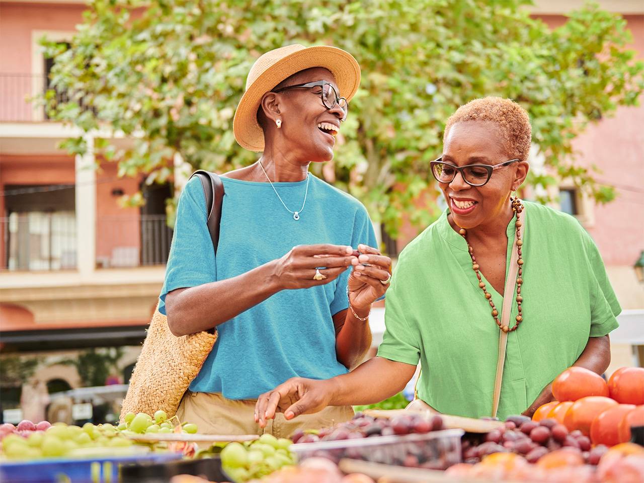 People selecting fresh fruits and vegetables at an outdoor market, supporting Food Wellness through healthy eating choices.