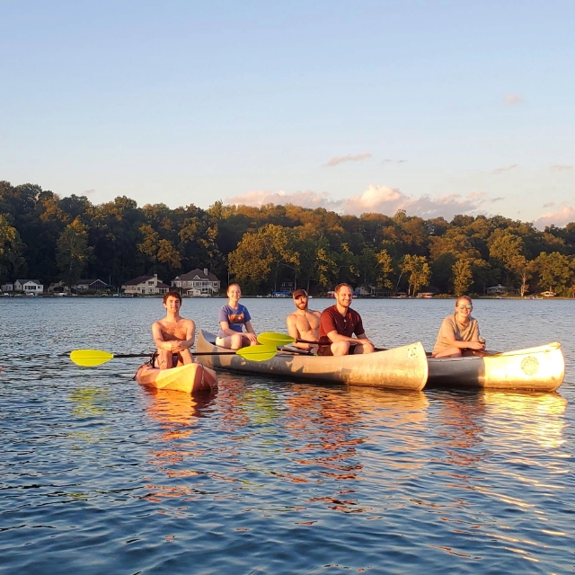 Group of residents in canoes on the lake during their wilderness retreat