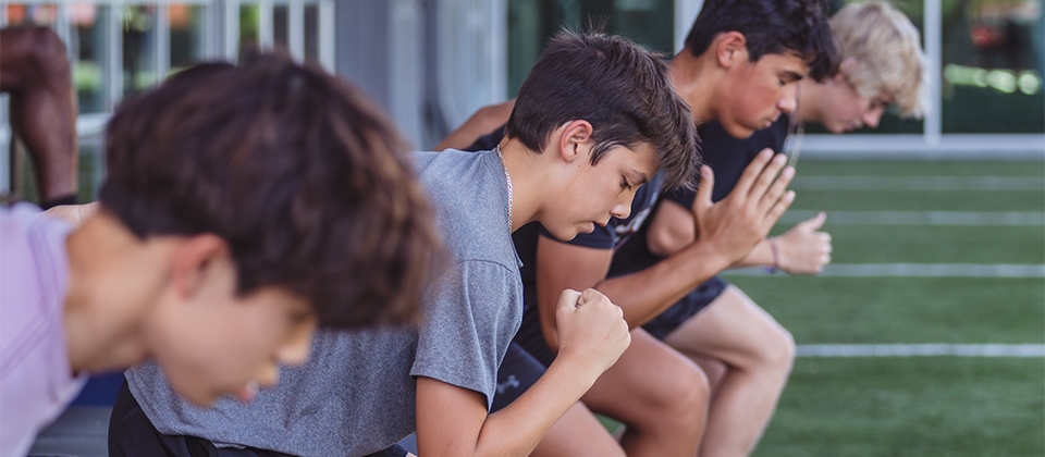 A diverse group of young individuals on a grassy field, engaged in a shared activity.
