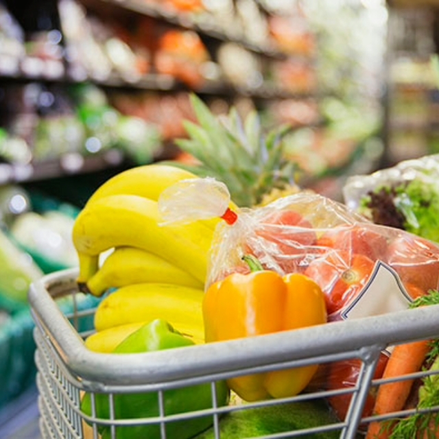 shopping cart in a grocery store full of colorful and fresh produce