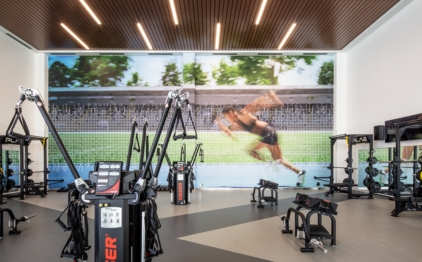 A gym featuring a large screen displaying a person performing a jump, emphasizing athletic training and sports performance.