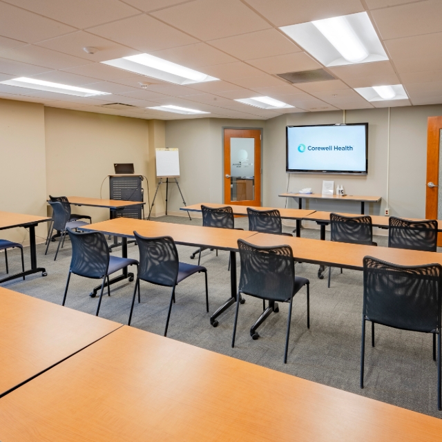 Table and chairs and a big monitor in the training room at St. Joseph