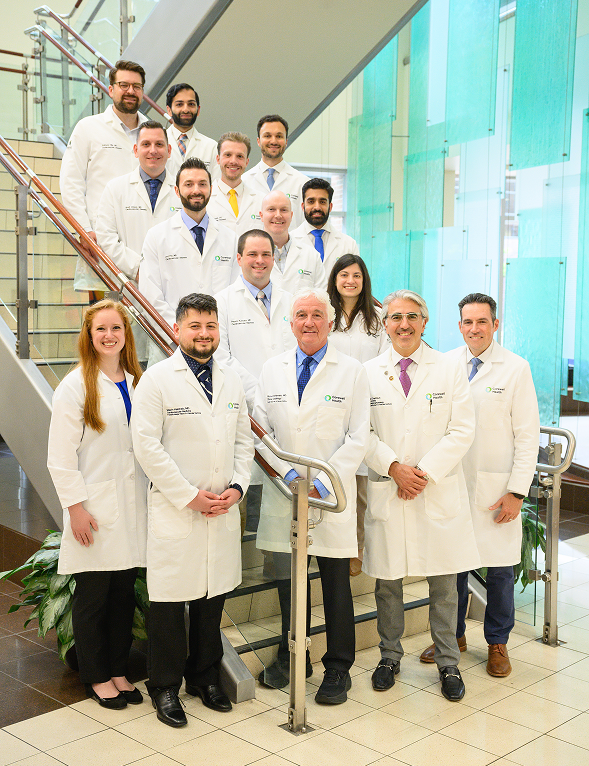 Team of doctors in white coats smiling for a photo at Corewell Health's Cardiovascular Disease Fellowship program.