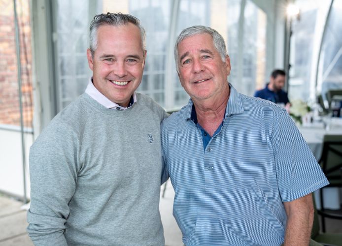 photo of two men smiling with their arms around each other