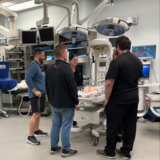 Staff and fellows standing around an operation table in the operating room