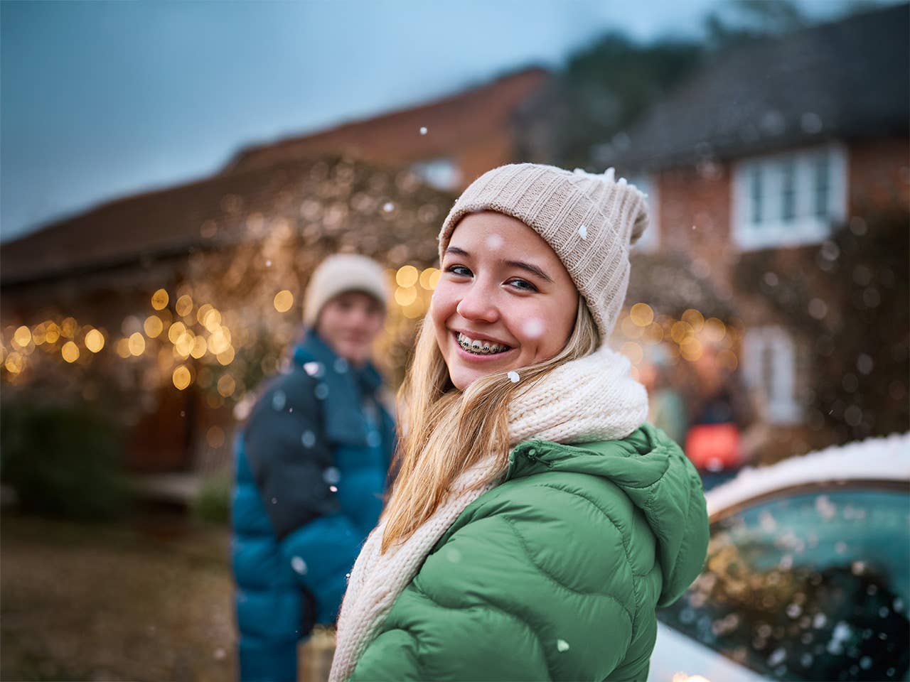 Teen girl smiling for the camera while other teens are in the background.