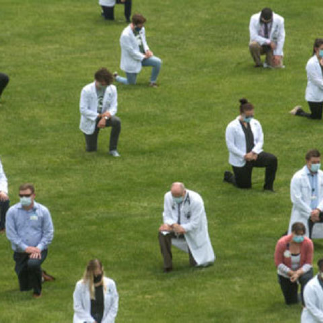 Various doctors kneeling in the grass