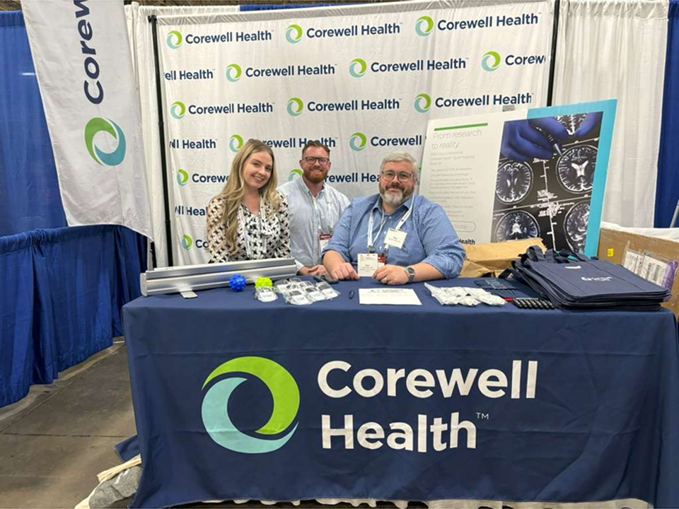 Physical Medicine and Rehabilitation residency representatives at a Corewell Health recruitment booth at a conference.