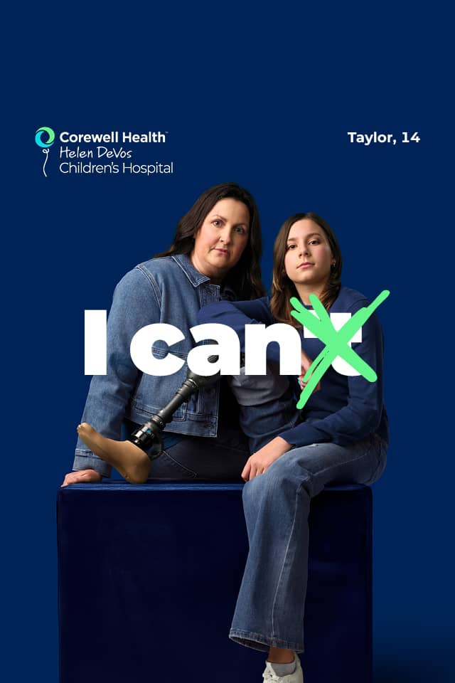 Taylor, a 14 year old patient, sits on a blue box with her prosthetic leg propped up, with her mom standing beside her