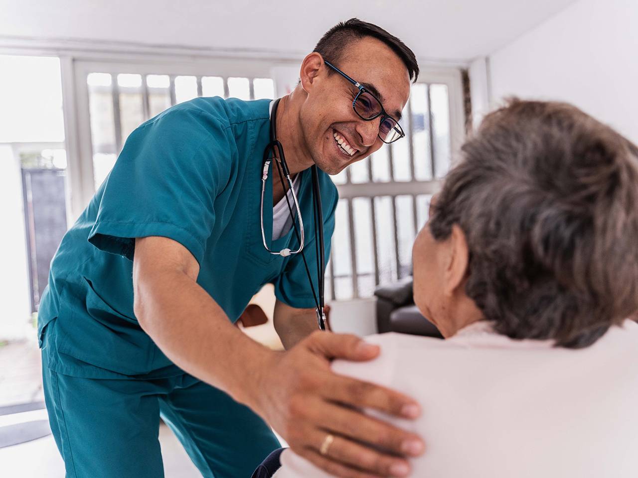 A doctor converses with an elderly woman in a medical office, discussing her health and treatment options.