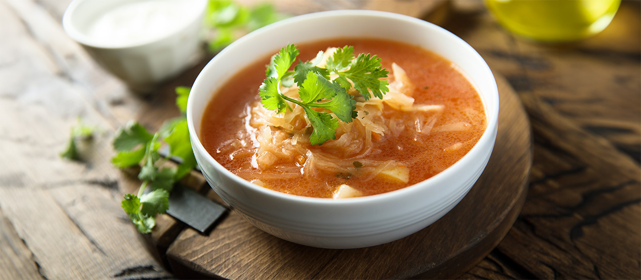 Bowl of unstuffed cabbage soup topped with fresh herbs, featuring cabbage in a hearty homemade meal.