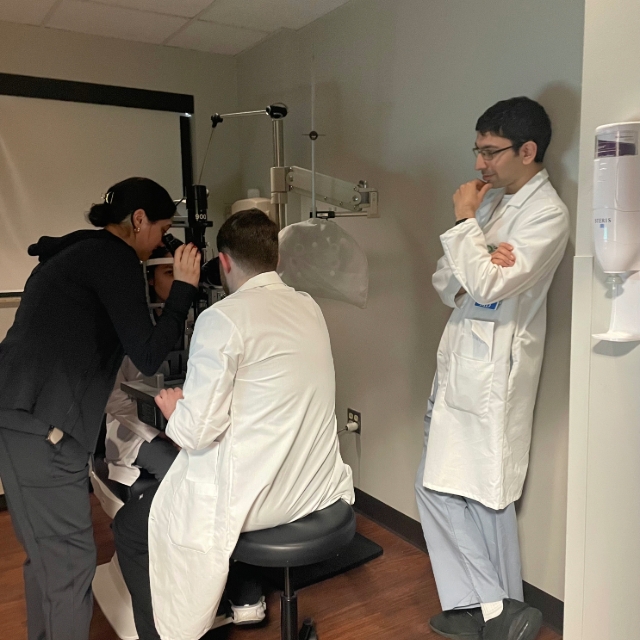 Group of residents watching each other perform an eye exam on the other residents