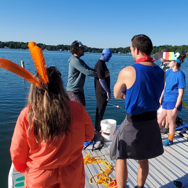 Group of residents dressed up in different themed attire on the dock by the lake at the wilderness retreat